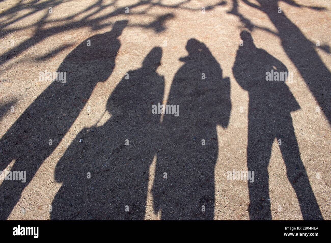 Schatten von Menschen und T-Stücken im Kies Stockfoto