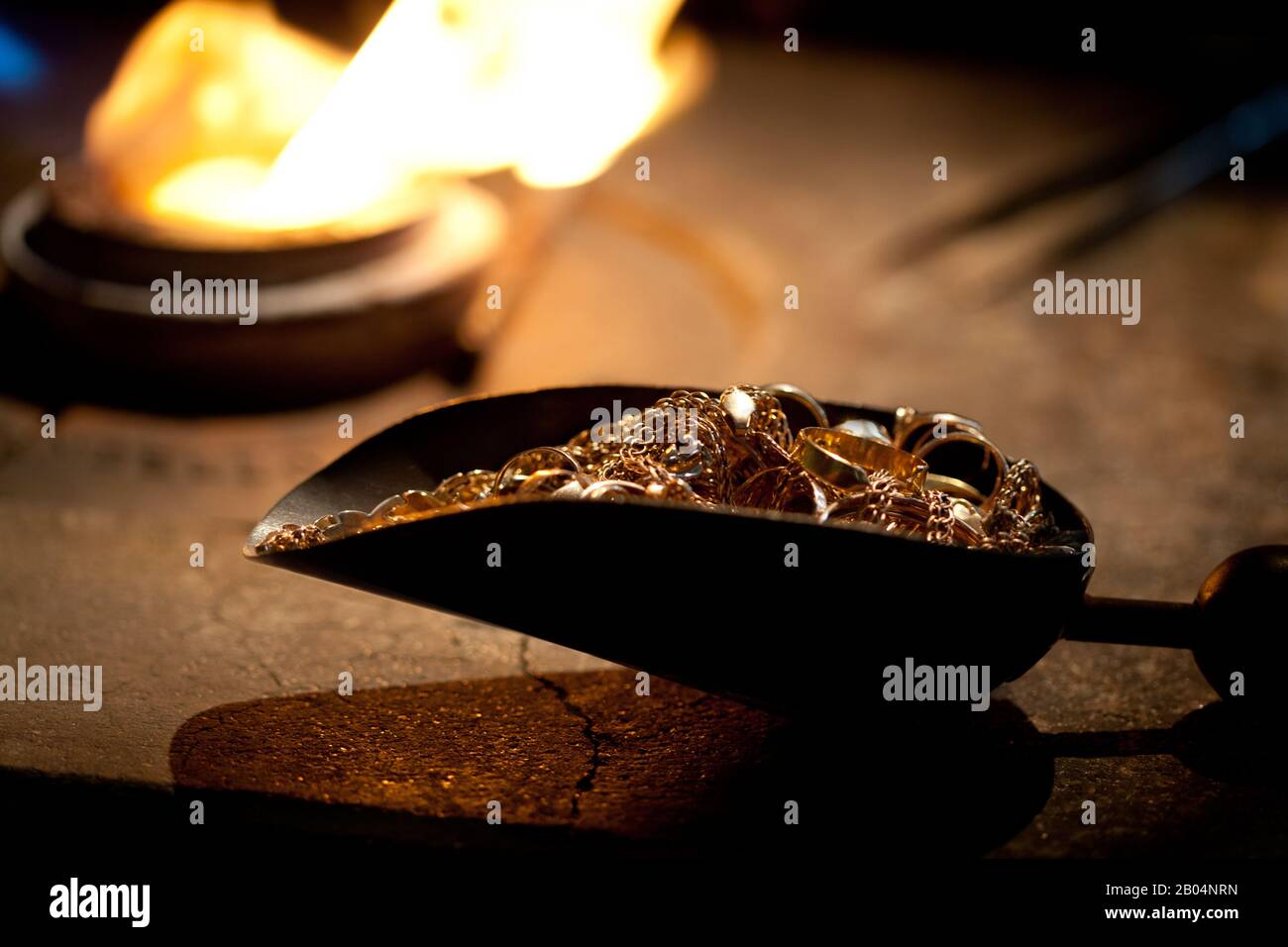 Schaufel mit goldenen Stücken zum Schmelzen im metallurgischen Ofen Stockfoto