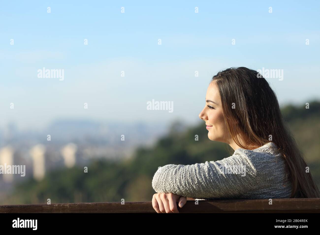 Seitenansicht Porträt einer zufriedenen Frau, die auf einer Bank sitzende Ansichten betrachtet Stockfoto