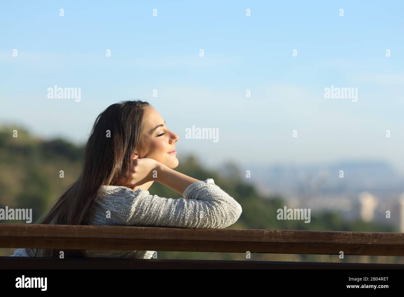 Seitenansicht Porträt der Frau Entspannungslinderung Sitzen auf einer Bank am Stadtrand Stockfoto