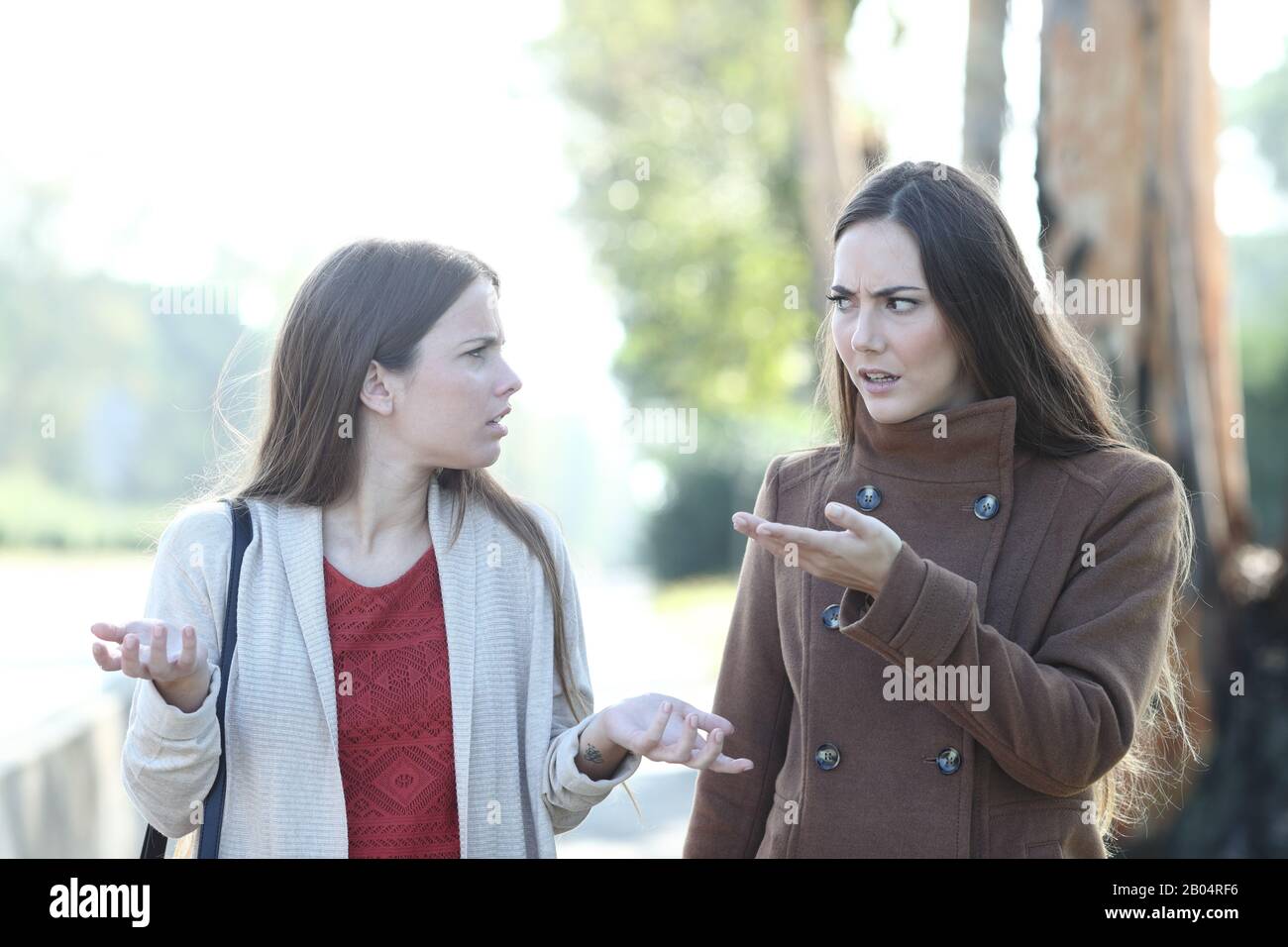 Frontansicht Porträt zweier wütenden Frauen, die im Winter in einem Park argumentieren Stockfoto
