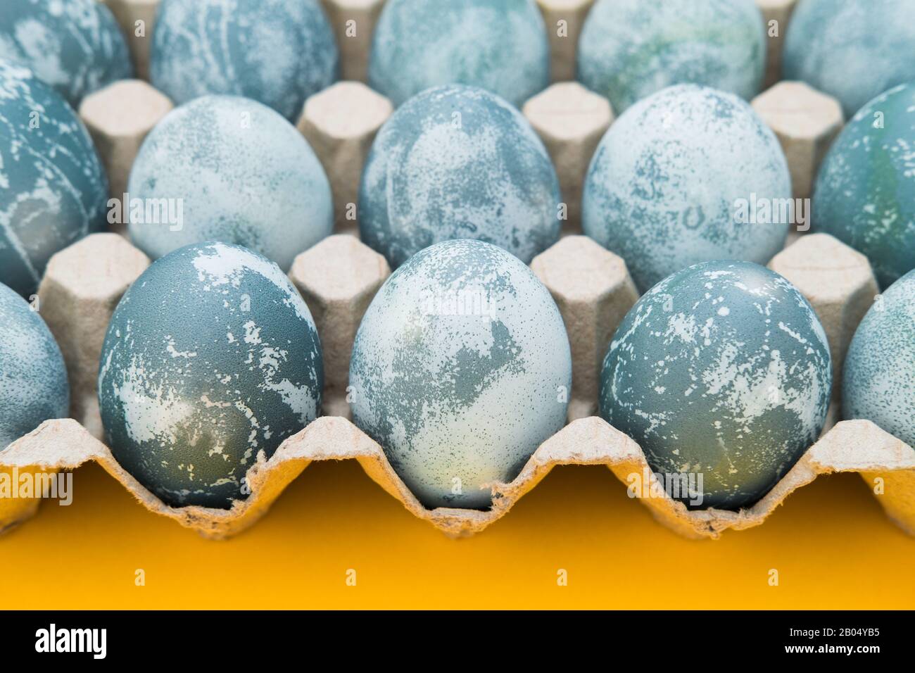 Blau strukturierte Ostereier auf hellgelber Ferienkulisse. Frühlingsferienkonzept. Copyspace. Flaches Lay. Draufsicht Stockfoto