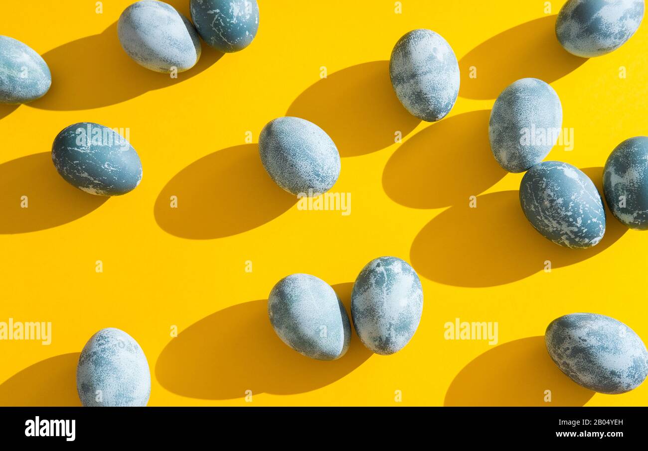 Blau strukturierte Ostereier auf hellgelber Ferienkulisse. Frühlingsferienkonzept. Copyspace. Flaches Lay. Draufsicht Stockfoto
