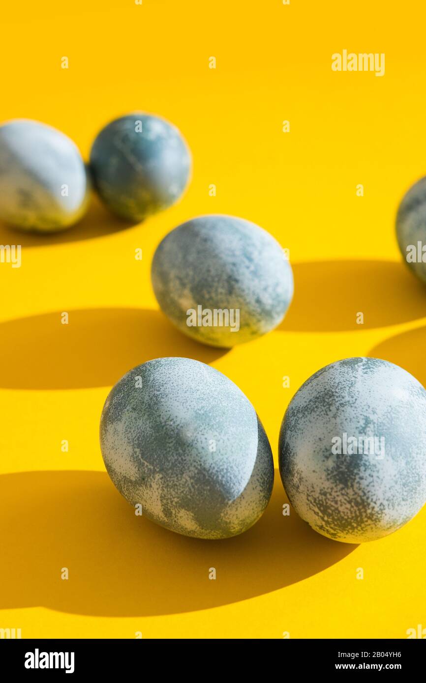 Blau strukturierte Ostereier auf hellgelber Ferienkulisse. Frühlingsferienkonzept. Copyspace. Flaches Lay. Draufsicht Stockfoto