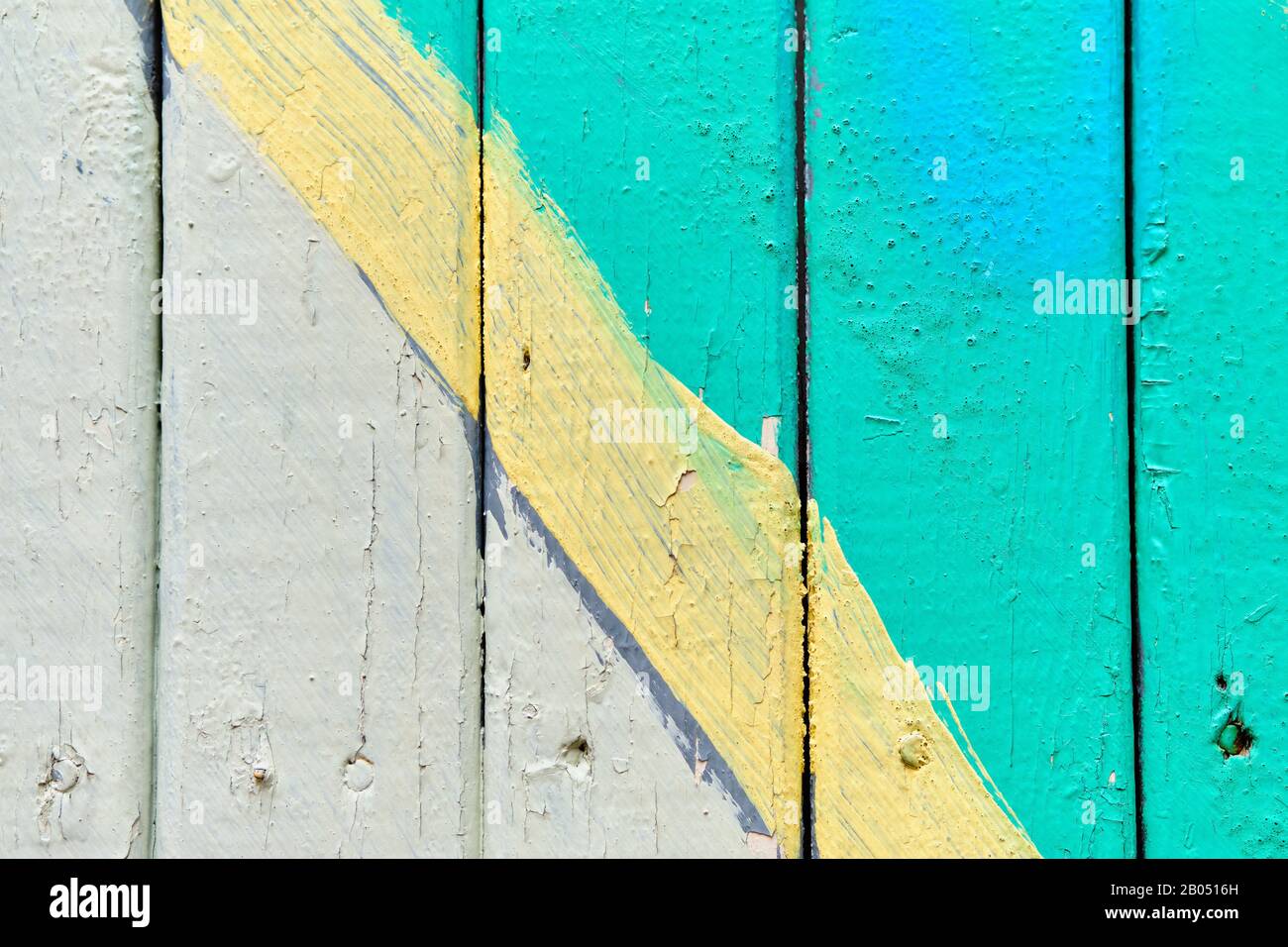 Holzzaun weiß und türkis mit gelber Linie lackiert. Nahaufnahme. Textur, Hintergrund Stockfoto