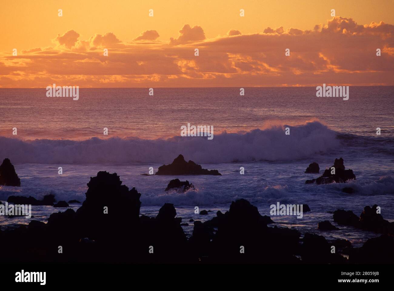 OSTERINSEL, HANGA ROA, BRANDUNG, DIE AUF FELSEN BRICHT, SONNENUNTERGANG Stockfoto