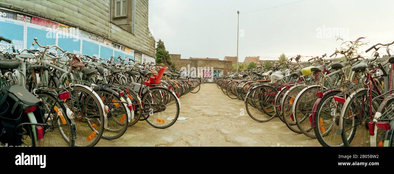 Fahrräder von Pendlern, die auf dem Parkplatz eines Bahnhofs, Gent-Sint-Pieters, Gent, Ostflandern, Flämische Region, Belgien geparkt sind Stockfoto
