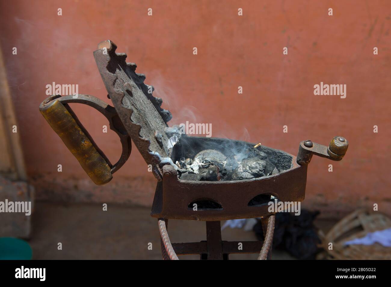 Straßenszene mit einem Holzkohleeisen, das vor einem Schneidergeschäft in Ouidah, Benin erhitzt wird Stockfoto