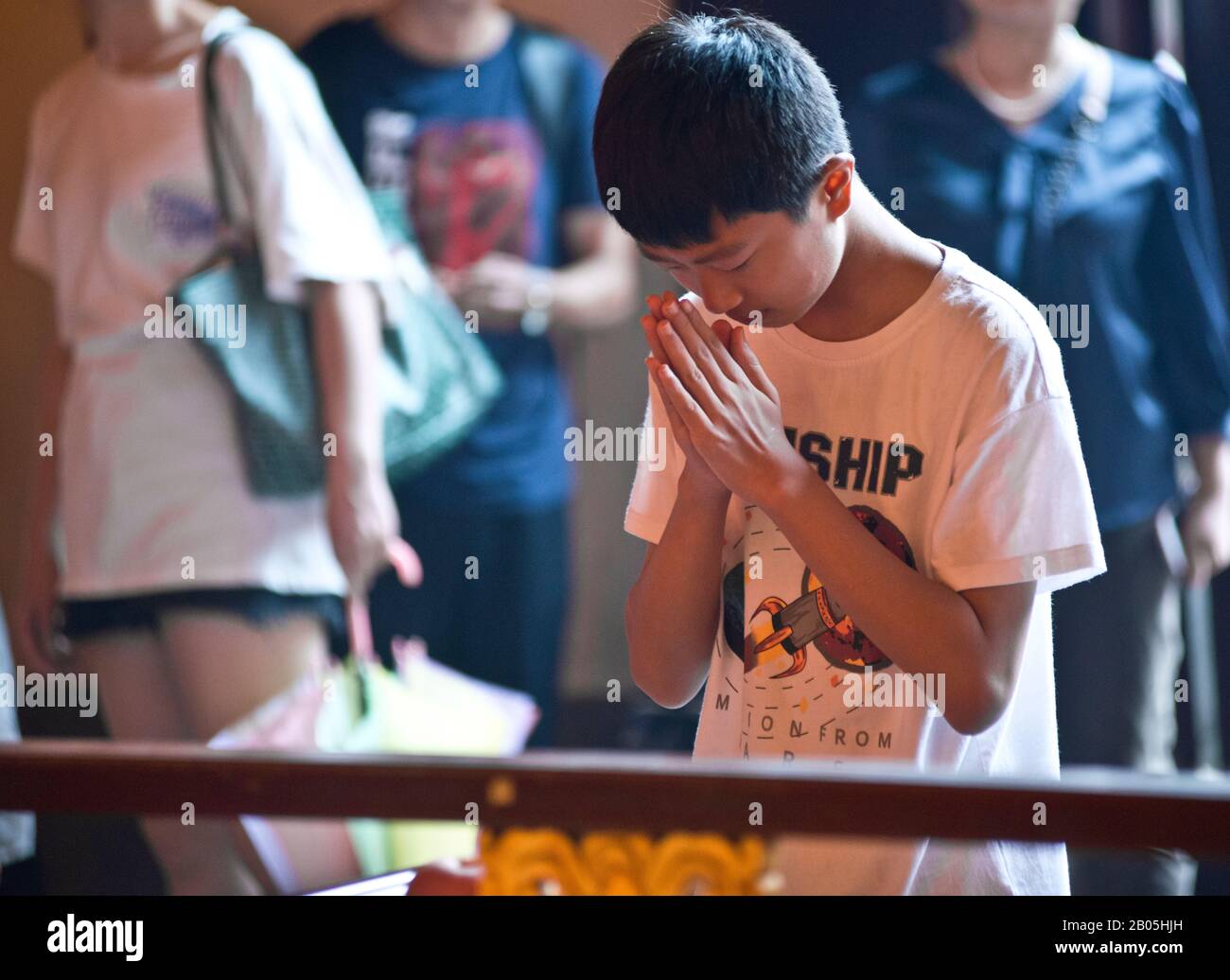 Ein junges Kind, das im Stadtgotttempel von Shanghai (China) betet Stockfoto