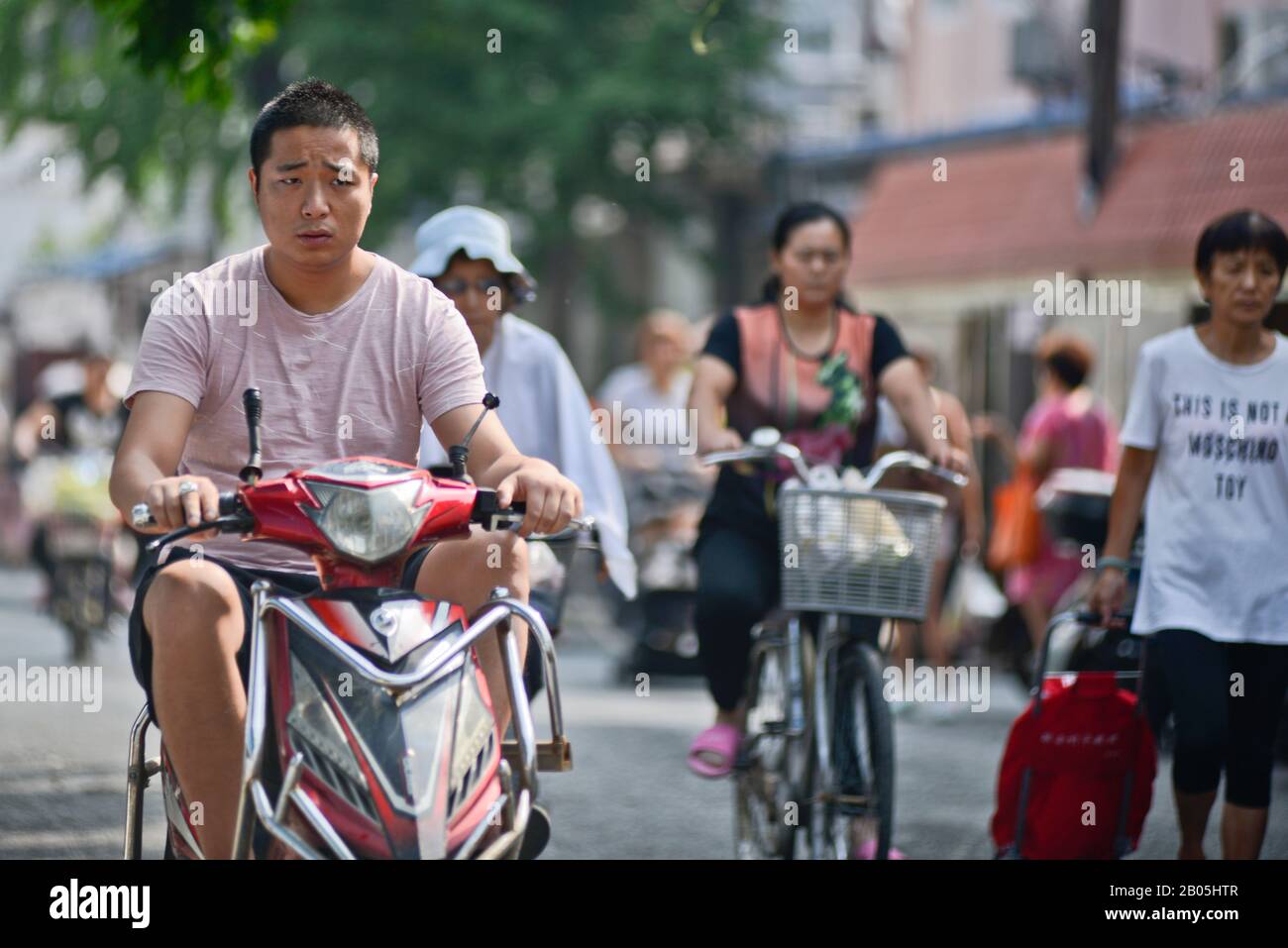 Chinesen in Rollern und Fahrrädern in der Penglai Road, Huangpu, Shanghai Stockfoto