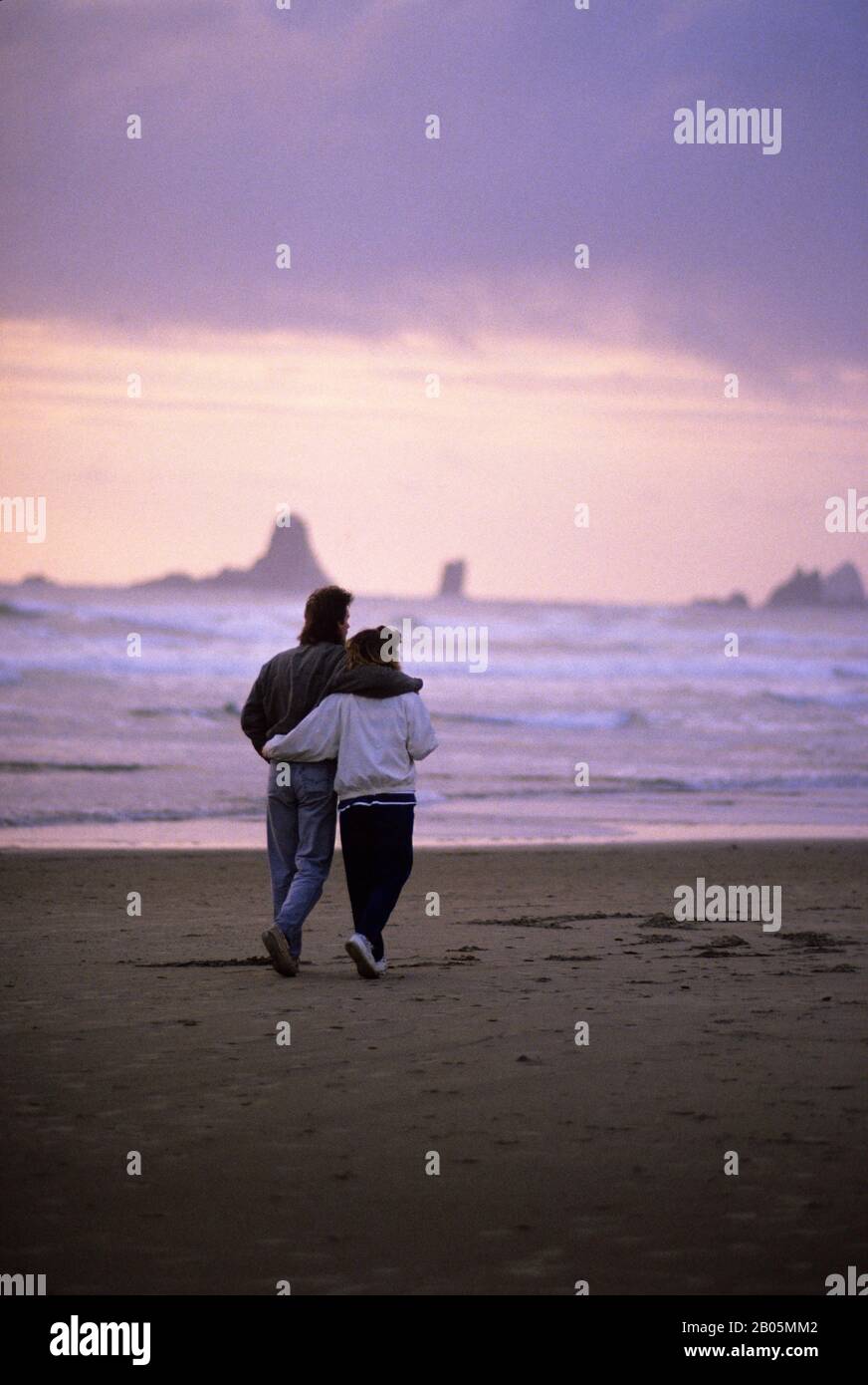 USA, OREGON, KANONE BEACH, PAAR, DIE ABENDS AM STRAND SPAZIEREN GEHEN Stockfoto