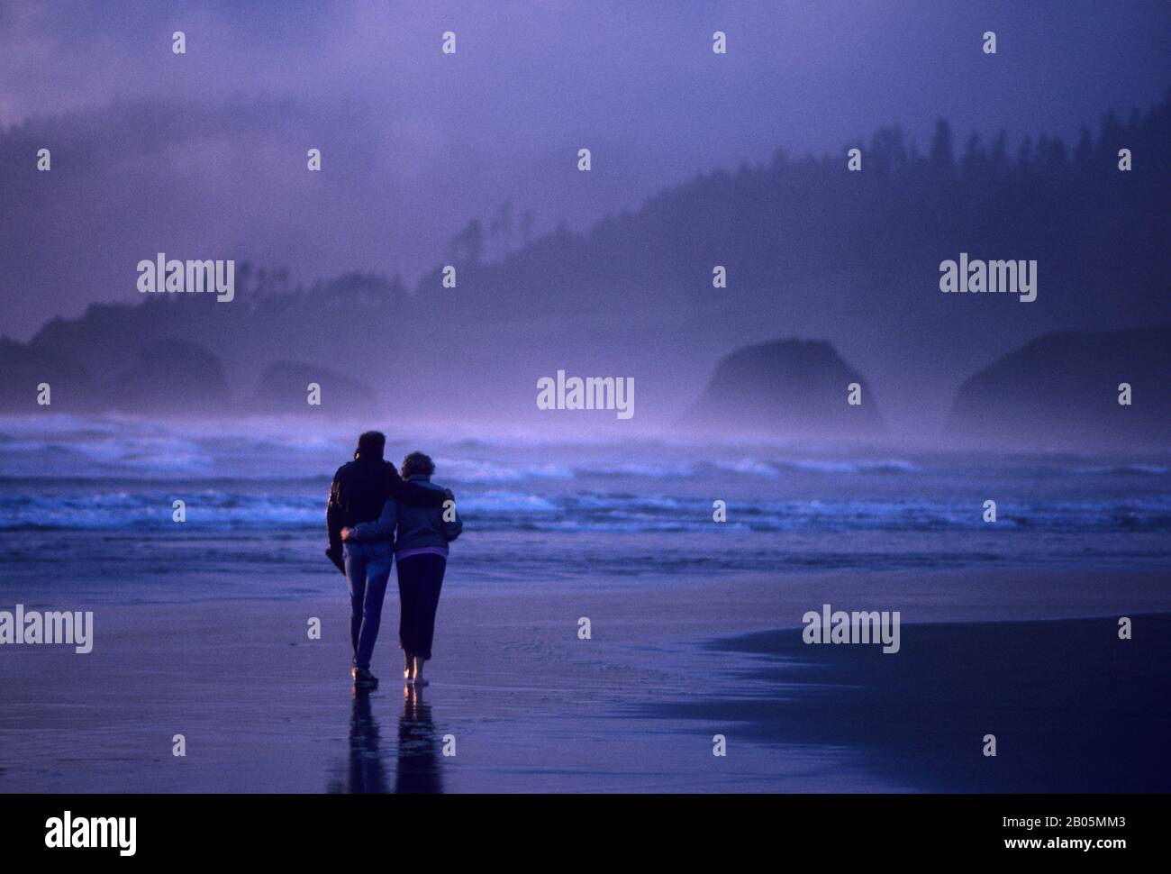 USA, OREGON, KANONE BEACH, PAAR, DIE ABENDS AM STRAND SPAZIEREN GEHEN Stockfoto