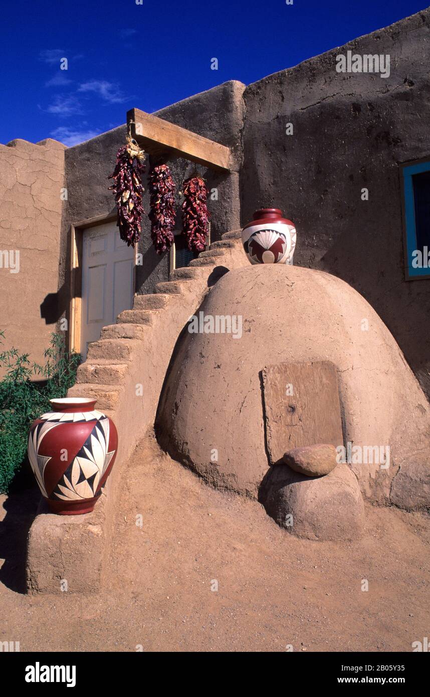 USA, NEW MEXICO, TAOS PUEBLO, ADOBE, ORNO, TRADITIONELLER OFEN, KERAMIK UND CHILE-PAPRIKA Stockfoto