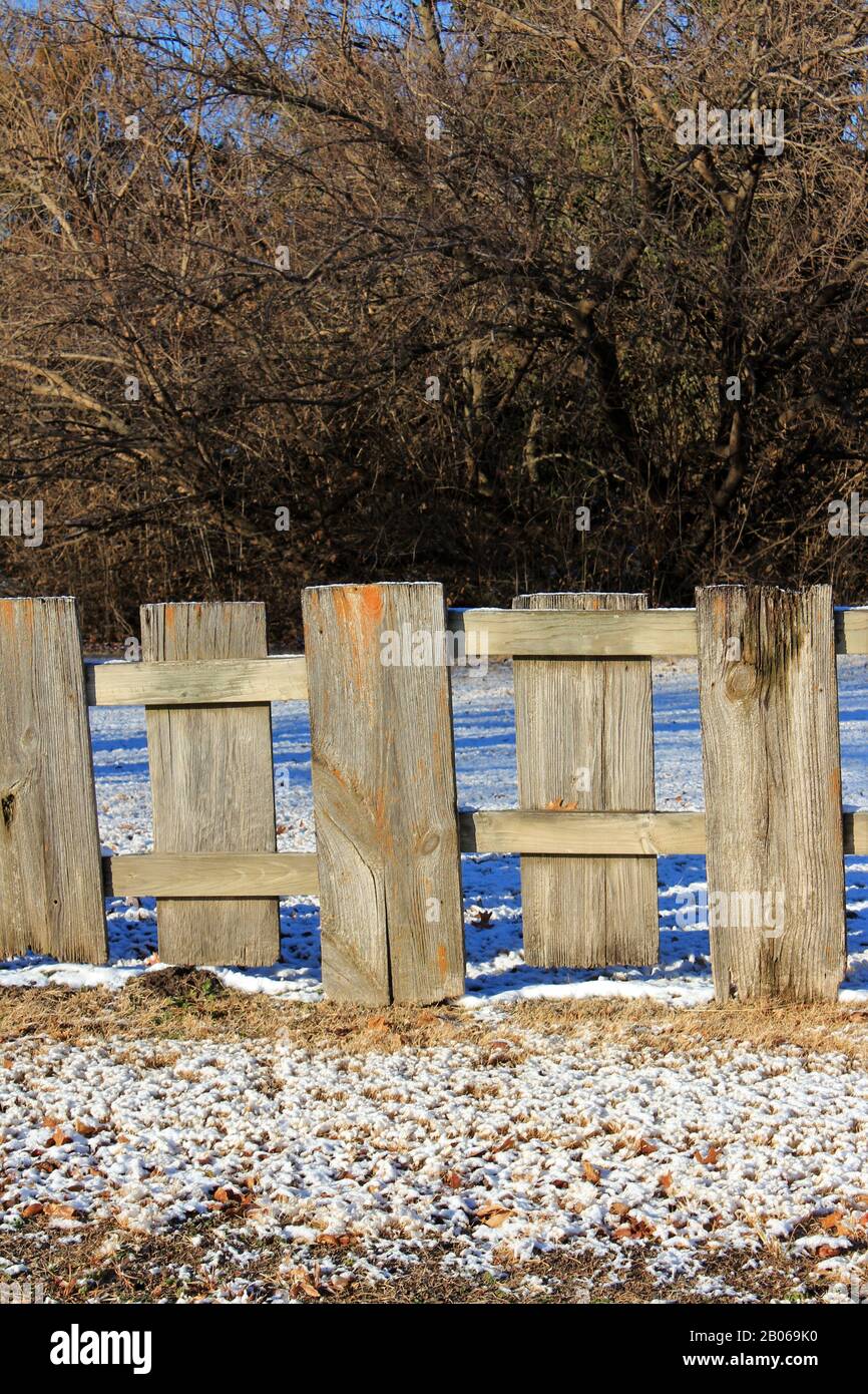 Kansas Country Board Zaun mit Schnee im Land mit Baum und braunem Gras. Stockfoto