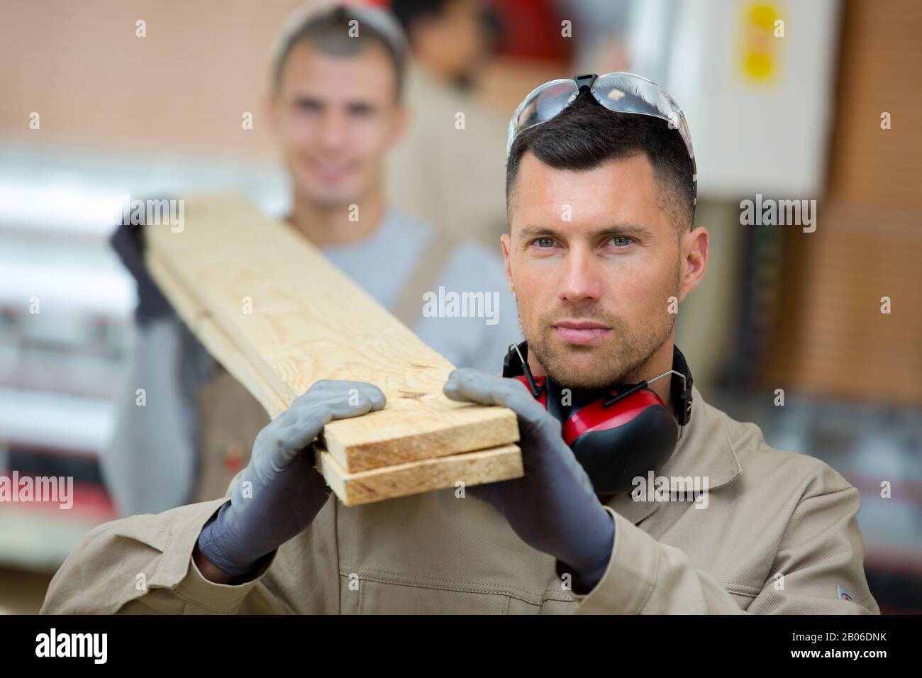 Zwei Handwerker, die ein Stück Holz tragen Stockfoto
