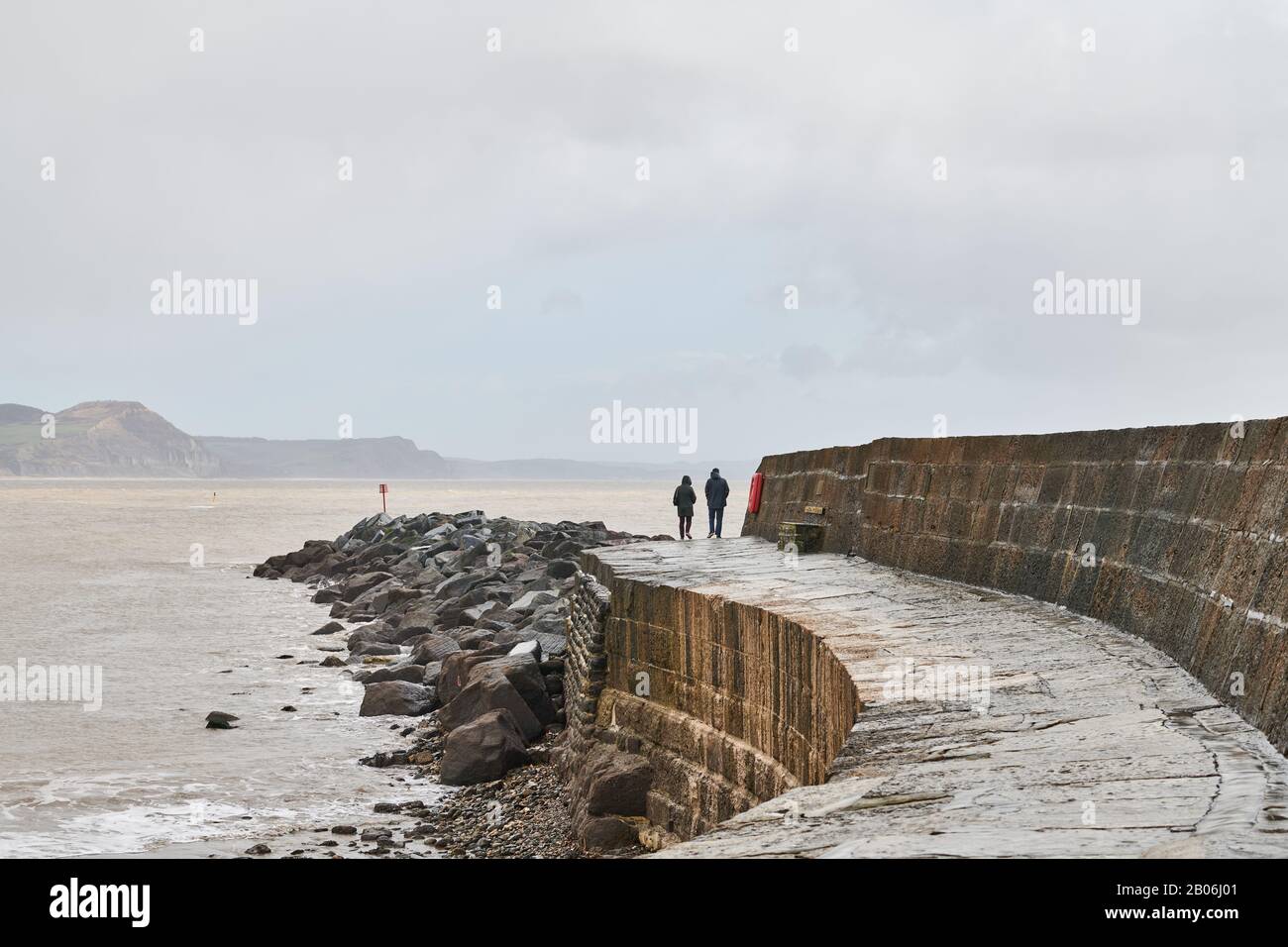 Brüstungsmauer am Hafen in der Lyme Bay bei Lyme Regis an der Ärmelkanalküste bei Dorset, England, als Sturmflut an einem Wintertag. Stockfoto