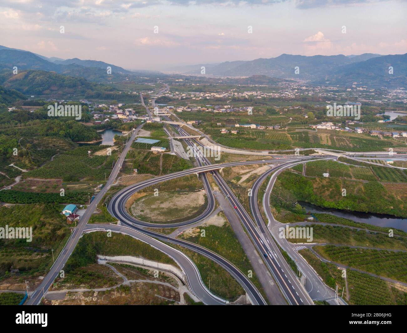 Luftansicht der Autobahn mit gebogener Rampe durch die japanische Landschaft vor Sonnenuntergang Stockfoto