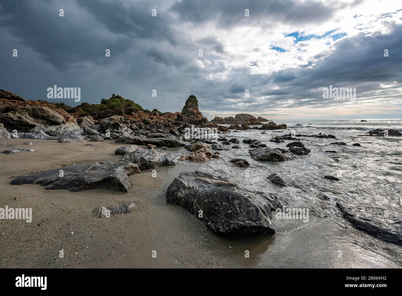 Felsige Küste, Felsen am Strand, dunkle Regenwolken, lange Zeit, Westküste, Südinsel, Neuseeland Stockfoto
