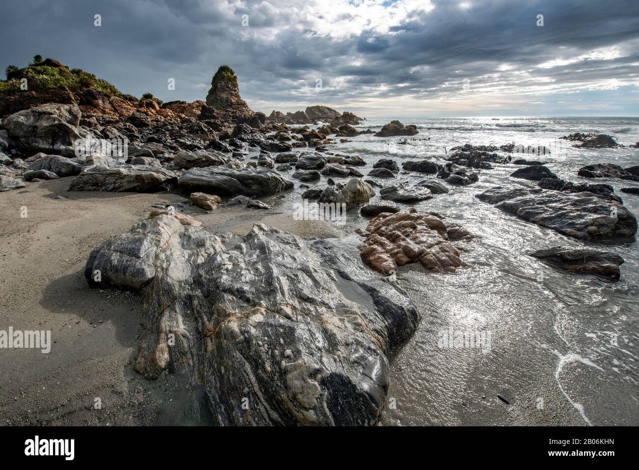 Felsige Küste, Felsen am Strand, dunkle Regenwolken, lange Zeit, Westküste, Südinsel, Neuseeland Stockfoto