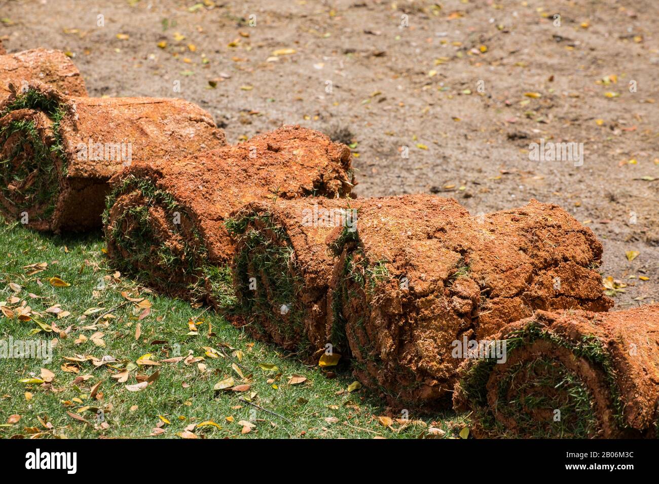 Reihen von Rasen aufgerollt werden, belichten Boden mit Flecken von Rasen Gräser angebracht, um bereit für die Landschaftsgestaltung Installationsprozess in der ausgewiesenen Bereich. Stockfoto