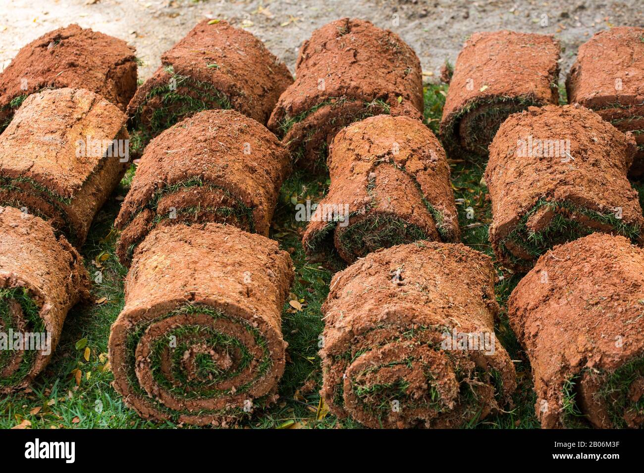 Reihen von Rasen aufgerollt werden, belichten Boden mit Flecken von Rasen Gräser angebracht, um bereit für die Landschaftsgestaltung Installationsprozess in der ausgewiesenen Bereich. Stockfoto