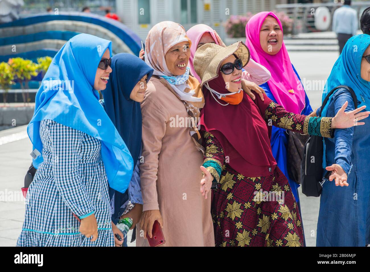 Mehrere Generationen muslimischer Frauen, die in Singapur gemeinsam einen Entführer für ein Gruppenbild tragen. Stockfoto