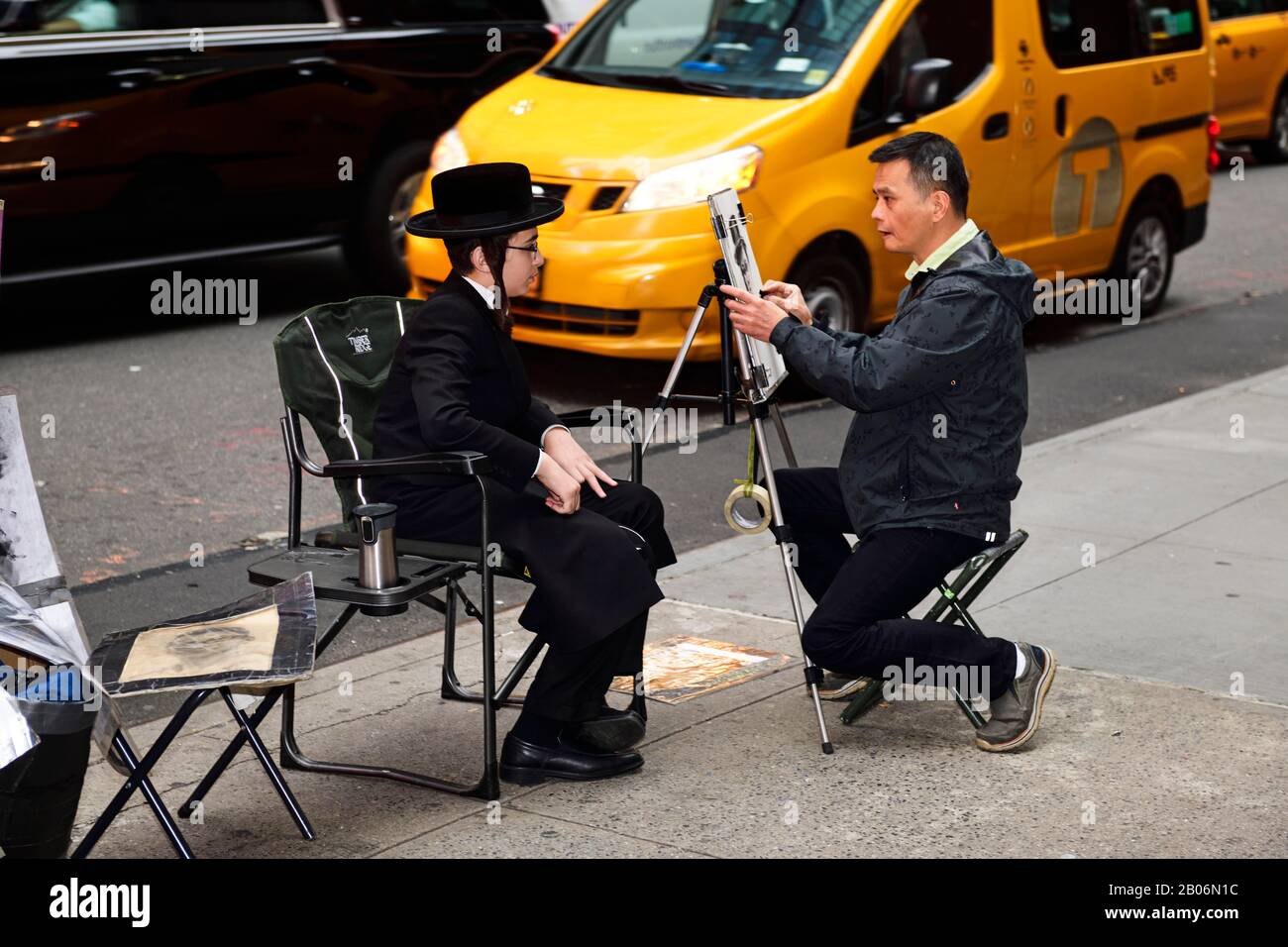 Ein jüdischer, orthodoxen Junge mit Tempelflucht und Hut wird auf Dem Times Square von einem Straßenmaler, Manhattan, New York City, New York State, USA, dargestellt Stockfoto