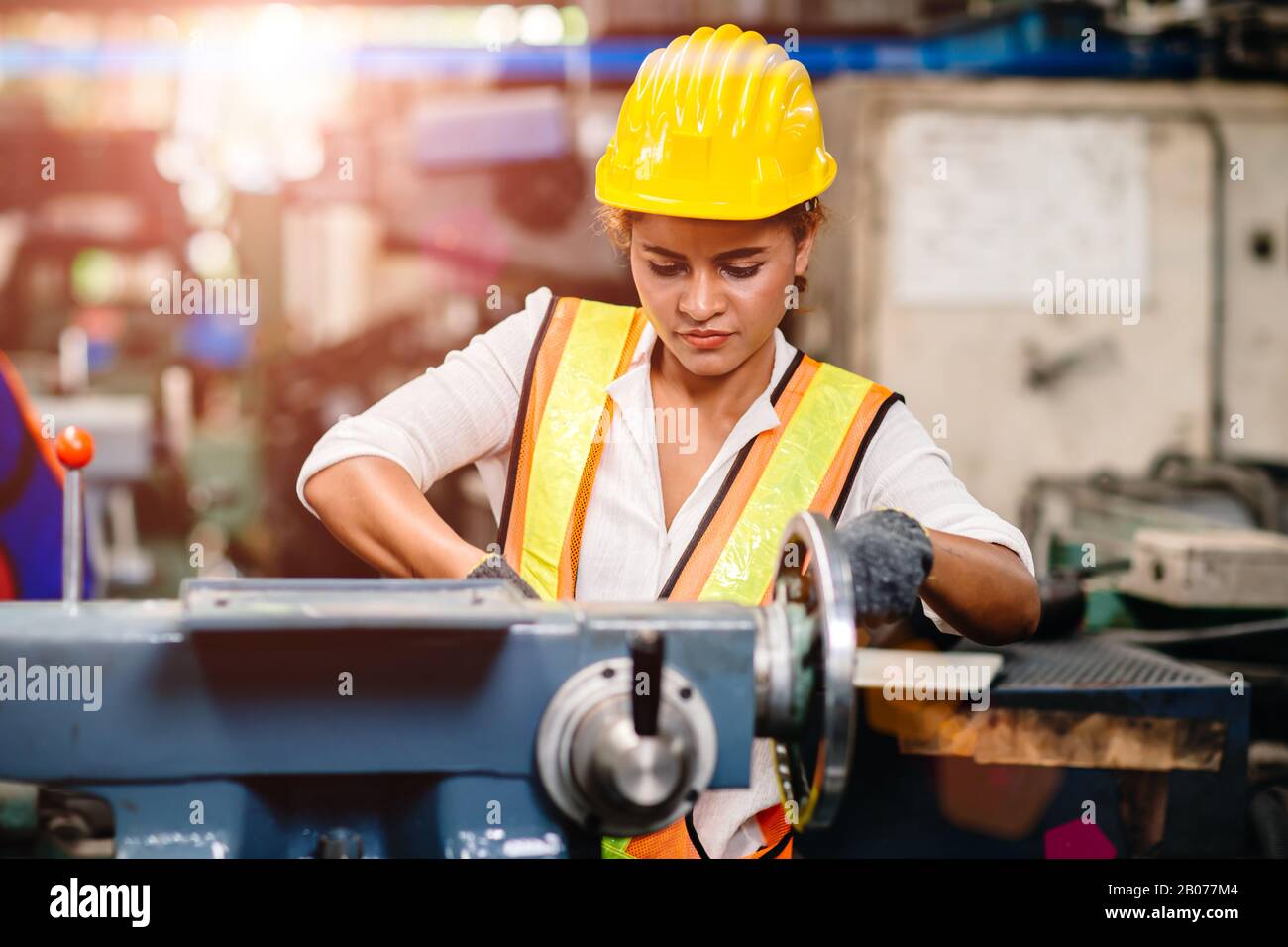 Mädchen Teenager Arbeiter afro-amerikanische Arbeit in Industriefabrik mit Schwerstahlmaschine. Stockfoto