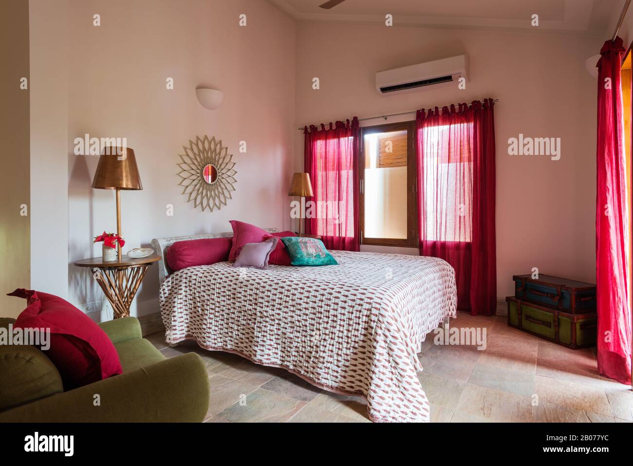 Schlafzimmer mit pinkfarbener Bettdecke und gemusterter Federdecke Stockfoto