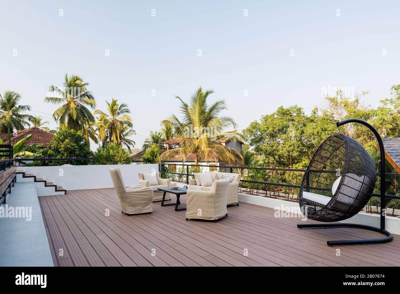 Gartenmöbel an Deck von Palmen Stockfoto