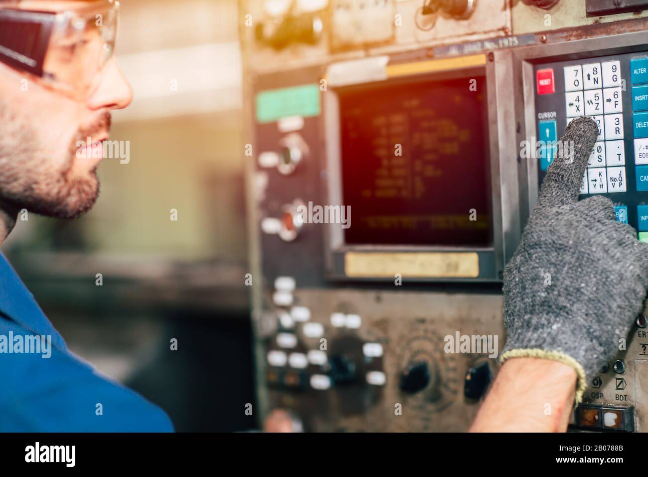 Der Arbeiter in der Nahaufnahme betreibt die Maschine, die Arbeitsbranche mit hoher Qualifikation und Sicherheitskleidung. Stockfoto