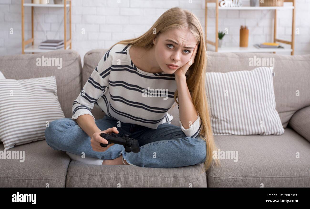 Langweilige Mädchen, die allein zu Hause Videospiele spielen Stockfoto
