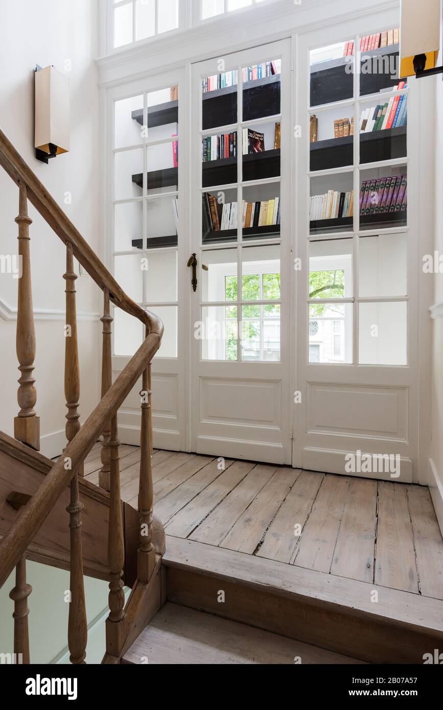 Holztreppe an Türen vor dem Bücherregal Stockfoto