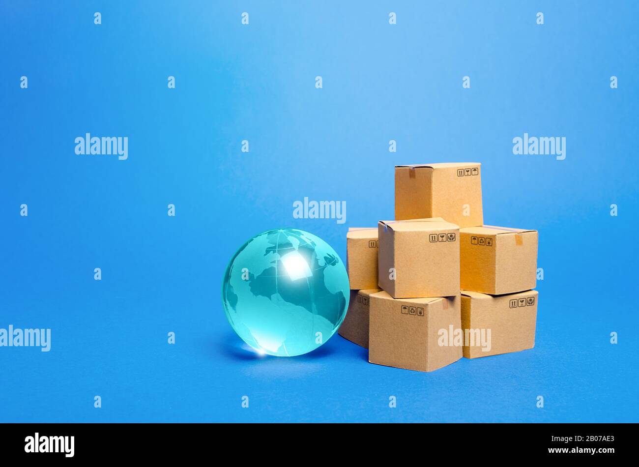 Blauer Glasglobus und Kartons. Internationale Verteilung des Welthandels. Lieferung von Waren, Versand. Weltwirtschaft, Import-Export-Frachttransporte Stockfoto