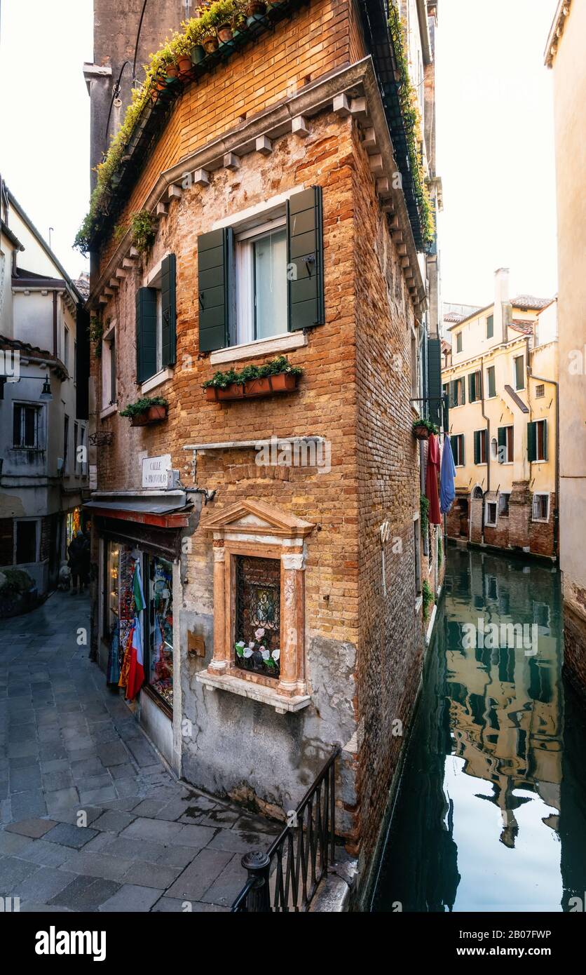 Blick auf das dünne bunte Haus zwischen Kanal und Straße in Venedig, Italien Stockfoto
