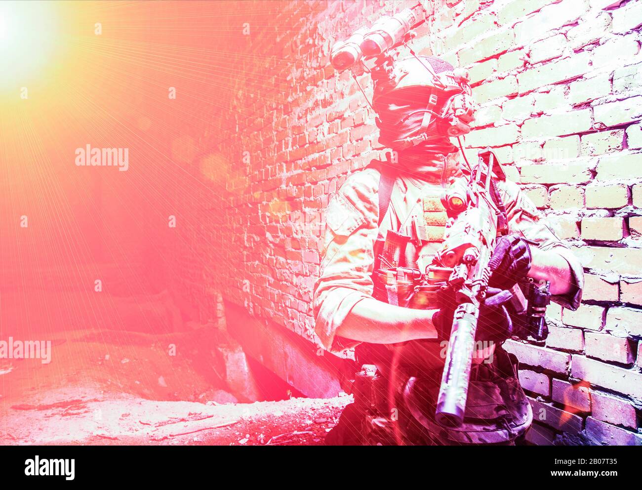 Spezialeinsatzkräfte Soldaten, Mannschaftskämpfer der Terrorismusbekämpfung mit Nachtsichtgerät auf Helm und Dienstgewehr, mit niedrigem Schlüssel in der Halle geschossene Ziegelwand Stockfoto