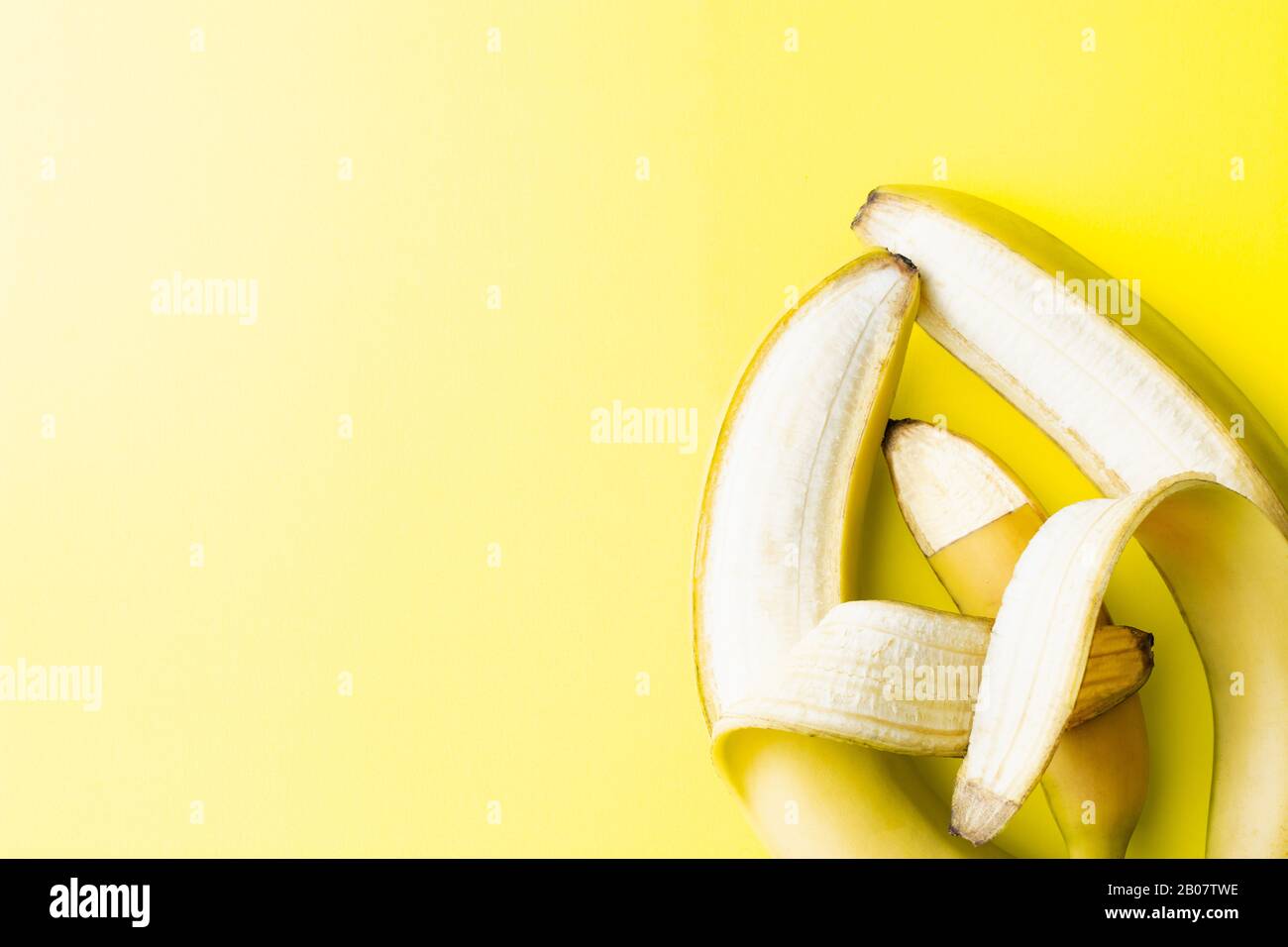 Konzeptionelles Bild von zwei großen Bananeneltern, die eine kleine Baby-Banane halten, die Elternschaft und Liebe ähnelt Stockfoto