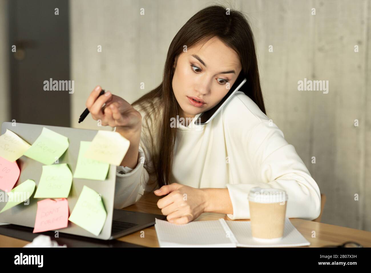 Freiberufliche Mädchen arbeiten, sprechen mit dem Smartphone über Laptop Stockfoto