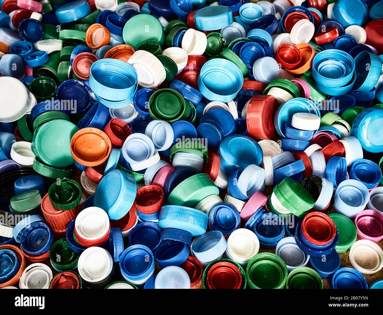 Hochauflösende Draufsicht im Hintergrund in verschiedenen Farben und Größen Kunststoff-Flaschenverschlüsse auf dem Boden. Stockfoto