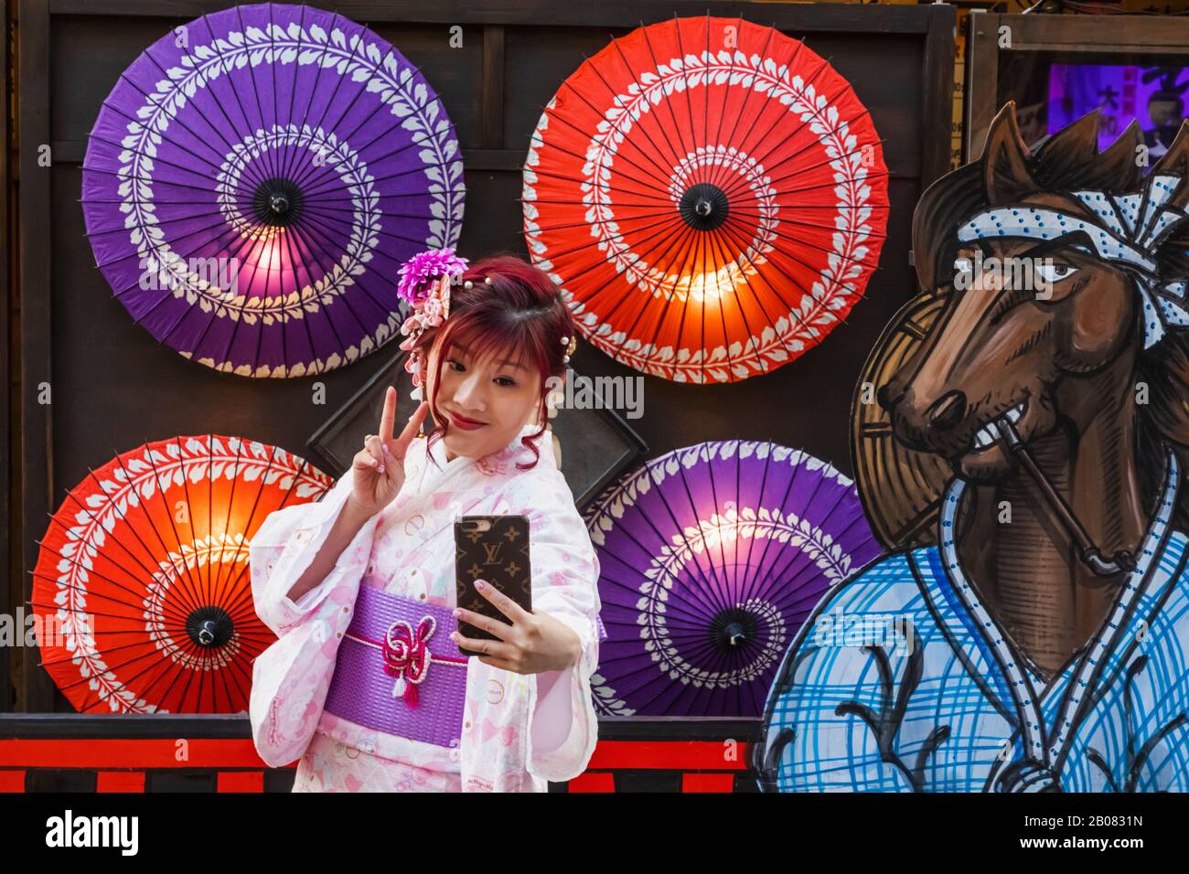 Japan, Honshu, Tokio, Asakusa, Frauen in Kimono, Die Erinnerungsfotos vor Farbenfrohen Papierschirmen Machen Stockfoto