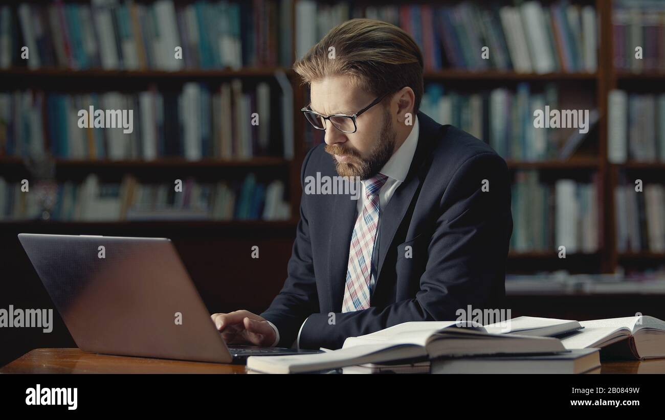 Geschäftsmann arbeitet Laptop in der Bibliothek Stockfoto
