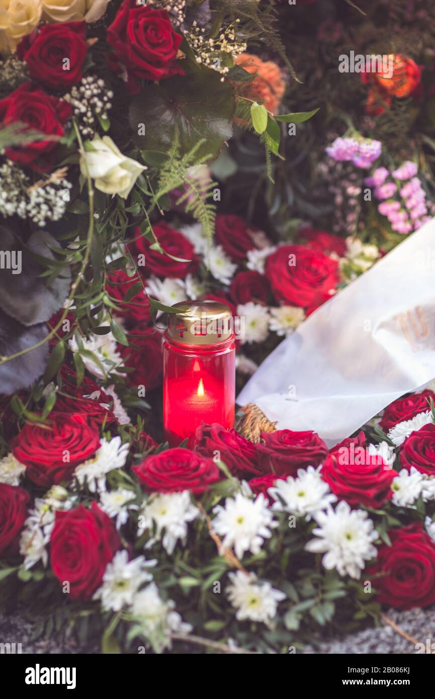 Kerze mit Blumen auf einem Grab Stockfoto