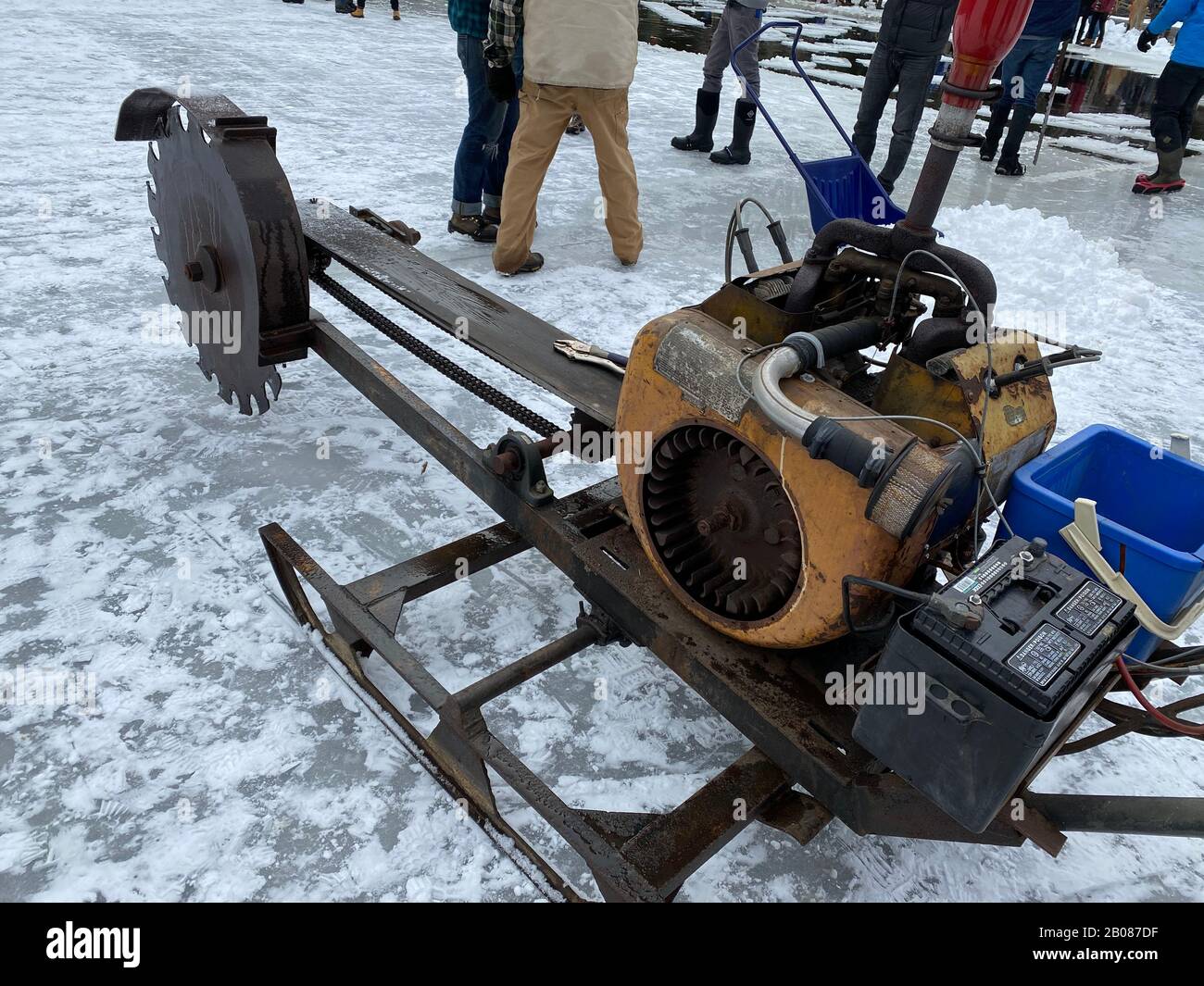 Dieses Foto stammt vom 16. Februar 2020 und wurde in South Bristol, Maine, auf dem Ice Harvest Festival in Thompson Pond aufgenommen. Es zeigt die Eisschneidemaschine, mit der sie die ersten Schnitte im Eis machen, um die Blöcke zu markieren. Sägen werden verwendet, um das Eis zu durchschneiden. Freiwillige sammeln sich, um Eis aus dem Teich zu schneiden, wie sie es in den 1820er Jahren an diesem Standort hatten. Das Gelände wurde in den 1980er Jahren geschlossen. Heute verwenden sie dieselben Geräte, die in der Vergangenheit verwendet wurden. Das Eis war in erster Linie für den lokalen Verbrauch bestimmt. Jetzt werden die Eisblöcke aufbewahrt und verwendet, um Eis für die jährliche Eiscreme Social im Sommer zu machen. Stockfoto