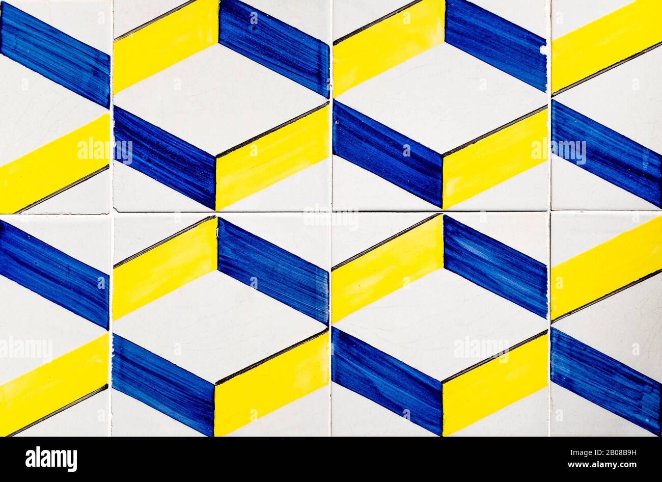Portugiesische, traditionelle Fliesen Azulejos mit blauem und gelbem Geometriemuster auf weißem Hintergrund, das einen optischen Täuschungseffekt erzeugt. Stockfoto