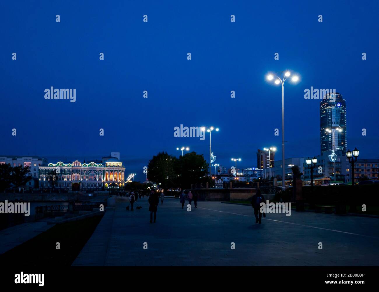 Die Leute, die nachts mit dem Sevastyanova Haus spazieren, beleuchteten die Lenin-Allee, Jekaterinburg, Sibirien, Russland Stockfoto
