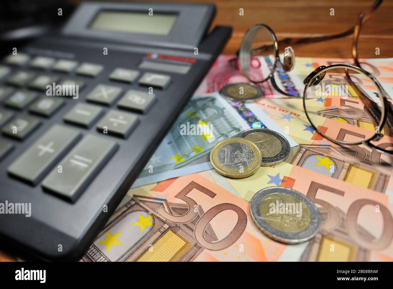 Euro-Banknoten und -Münzen sowie Taschenrechner Stockfoto