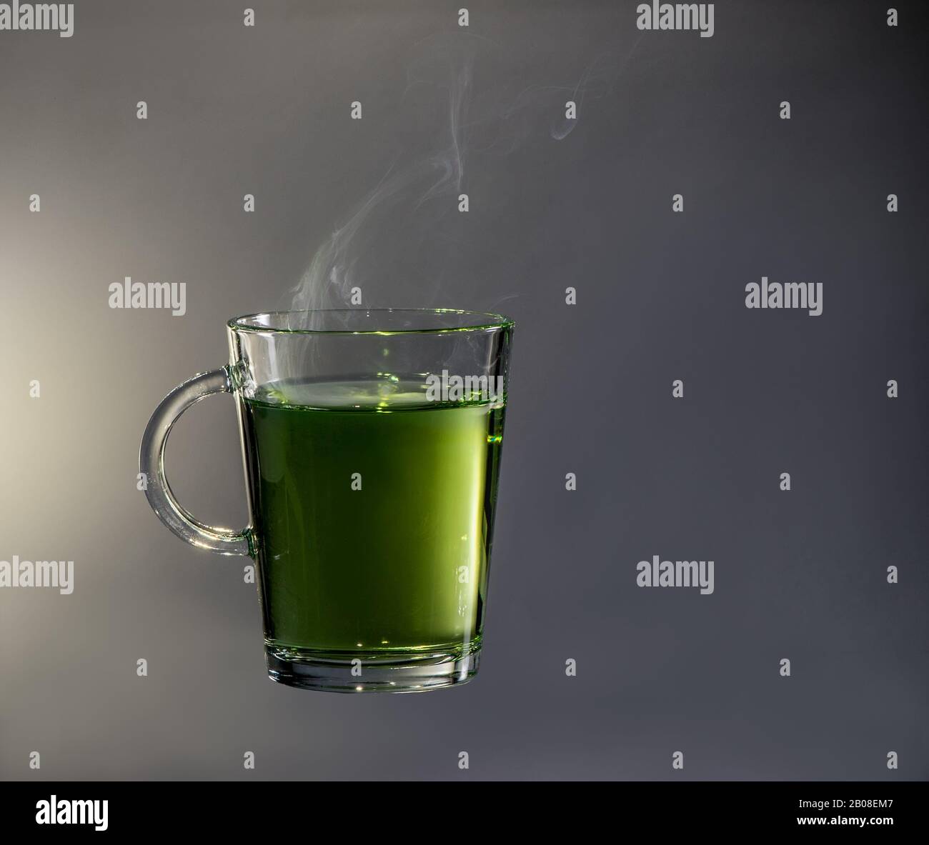 Teeglas mit heißem grünem Tee und Dampf auf der Oberfläche Stockfoto