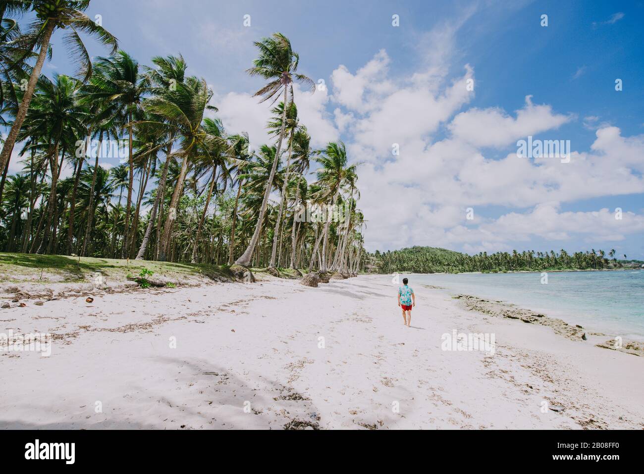 Man steht am Strand und genießt den tropischen Ort mit Blick auf das karibische Meer und Palmen im Hintergrund. Konzept über Reisen an Stockfoto