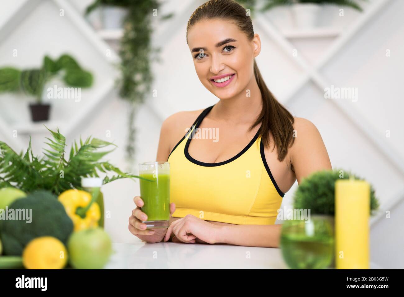 Sporternährung. Aufgeregtes Mädchen, das Glas mit grünem Entgiftungsgetränk hält Stockfoto