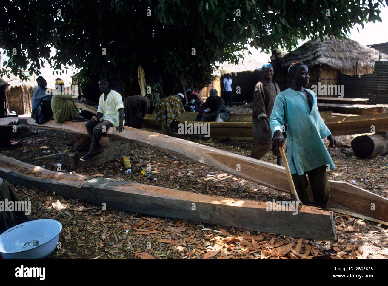 AFRIKA, GAMBIA, GAMBIA-FLUSS, FISCHERDORF, SCHNITZEN VON AUSGEGRABENEN KANUS Stockfoto